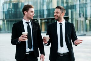 To professionelle mænd nyder takeaway-kaffe
